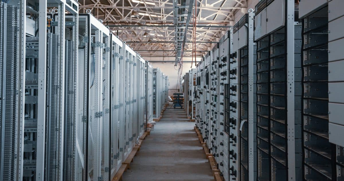 Warehouse aisle with rows of decommissioned server racks staged on pallets