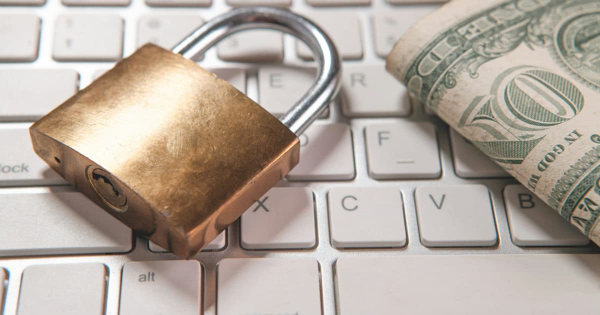 Padlock and cash on a laptop keyboard representing data security in IT resale